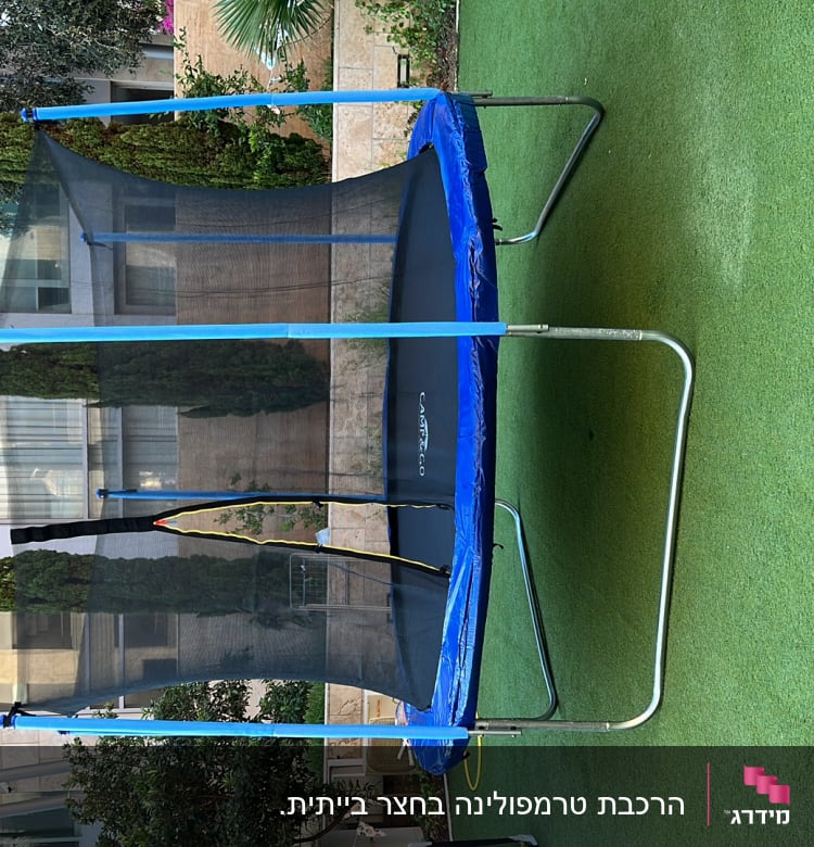 טרמפולינה עם רשת בטיחות על דשא ירוק